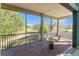 Screened brick balcony with seating overlooks a lush, green tree lined area at 4579 Tuscana Dr, Sarasota, FL 34241