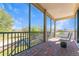 Screened in brick balcony with views of trees and seating for two at 4579 Tuscana Dr, Sarasota, FL 34241