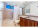 Well-lit bathroom featuring a bathtub with shower, wood cabinets, neutral tile, and a pristine white toilet at 4579 Tuscana Dr, Sarasota, FL 34241