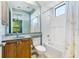 Bright bathroom features a tub-shower combo, floral shower curtain, and vanity with a light wood cabinet at 4579 Tuscana Dr, Sarasota, FL 34241