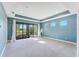 Spacious carpeted bedroom with recessed lighting has private balcony access and three sunny windows at 4579 Tuscana Dr, Sarasota, FL 34241
