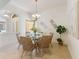 Bright dining room features a chandelier, round glass table, and woven chairs at 4579 Tuscana Dr, Sarasota, FL 34241