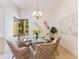Cozy dining room with a round glass table set for six, bathed in natural light at 4579 Tuscana Dr, Sarasota, FL 34241