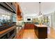 Gourmet kitchen boasts hardwood floors, custom cabinets, granite counters and island with stove at 4579 Tuscana Dr, Sarasota, FL 34241