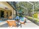 Covered patio has outdoor seating, ceiling fan and a view to the lawn in a screened enclosure at 4579 Tuscana Dr, Sarasota, FL 34241