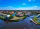 Beautiful aerial view of canal-front homes with boat docks in a waterfront community on a sunny day at 4700 Mainsail Dr, Bradenton, FL 34208
