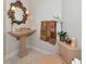 Elegant bathroom featuring a pedestal sink, ornate mirror, decorative towels, and matching toilet for a cohesive design at 4700 Mainsail Dr, Bradenton, FL 34208
