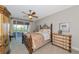 Bedroom featuring a ceiling fan, dresser, iron bed, and balcony access at 4700 Mainsail Dr, Bradenton, FL 34208