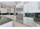 Bright kitchen showcasing stainless steel refrigerator and white cabinets with ample storage at 4700 Mainsail Dr, Bradenton, FL 34208
