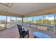 Inviting screened lanai with comfortable rocking chairs and water views, perfect for enjoying the outdoors at 4700 Mainsail Dr, Bradenton, FL 34208