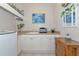 Laundry room with white cabinets and countertops, a stainless steel toaster, and decorative mirror and greenery at 4700 Mainsail Dr, Bradenton, FL 34208