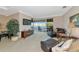 Inviting living room with comfortable seating, a TV, and access to a screened lanai, creating an indoor-outdoor living space at 4700 Mainsail Dr, Bradenton, FL 34208