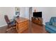 Bright office featuring a large wooden desk, TV on credenza, and comfortable seating, creating a functional workspace at 4700 Mainsail Dr, Bradenton, FL 34208