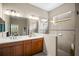 Bathroom featuring double sinks, a walk-in shower with glass, and a window at 4734 Claremont Park Dr, Bradenton, FL 34211