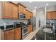 Kitchen featuring stainless steel appliances, wooden cabinets, dark countertops and tile flooring at 4734 Claremont Park Dr, Bradenton, FL 34211