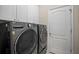 Modern laundry room with front-loading LG washer and dryer, plus white cabinets above at 4734 Claremont Park Dr, Bradenton, FL 34211