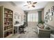 Bright office features built-in bookshelves, a modern desk, and a comfortable sofa at 4734 Claremont Park Dr, Bradenton, FL 34211