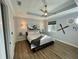 Comfortable bedroom featuring wood floors, ceiling fan, unique decor, and bright light from the window at 48 Lark Dr, Placida, FL 33946