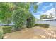 Charming backyard area with a wood deck and lush green shrubs and trees at 5012 Eastchester Dr, Sarasota, FL 34234