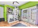 Bonus room with lime green walls, shelving, weights, and tile flooring with view to outdoor patio at 5012 Eastchester Dr, Sarasota, FL 34234