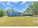 Front exterior view of a charming blue house with a carport and well-maintained lawn at 5012 Eastchester Dr, Sarasota, FL 34234