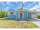 Charming single-story home with a light blue exterior, carport, and a welcoming red front door at 5012 Eastchester Dr, Sarasota, FL 34234