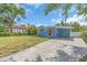 Quaint single story home with a carport and long driveway surrounded by mature trees and green lawn at 5012 Eastchester Dr, Sarasota, FL 34234