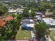 Aerial view of cozy blue house with well-maintained lawn in a quiet neighborhood setting, framed by lush greenery at 5012 Eastchester Dr, Sarasota, FL 34234
