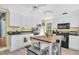 White kitchen with modern appliances, a wooden island, and eat in breakfast stools at 5012 Eastchester Dr, Sarasota, FL 34234