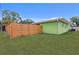 A fenced backyard with lush lawn and a green exterior, providing a secure and aesthetically pleasing outdoor space at 5353 Starwood Pl, Sarasota, FL 34232