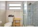 Bright bathroom featuring a tiled shower and a toilet with a wooden accent table at 5353 Starwood Pl, Sarasota, FL 34232