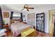 Cozy bedroom featuring ceiling fan, laminate floors, colorful accents, and natural light at 5353 Starwood Pl, Sarasota, FL 34232
