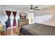 Bedroom with neutral walls, a ceiling fan, and a dresser with a large mirror and television at 5353 Starwood Pl, Sarasota, FL 34232