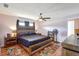 Primary bedroom with a wooden accent wall, fan, bedside lamps, and colorful decor at 5353 Starwood Pl, Sarasota, FL 34232