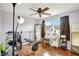 Bedroom featuring wood floors, ceiling fan, weight bench, and desk at 5353 Starwood Pl, Sarasota, FL 34232