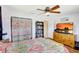 Bedroom with laminate floors featuring ceiling fan, colorful accents, and lots of storage at 5353 Starwood Pl, Sarasota, FL 34232