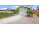 View of the side of the home with a white, one-car garage and a paved driveway at 5353 Starwood Pl, Sarasota, FL 34232