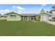 Charming, one-story home with a lush green lawn, bright green exterior, and attached one car garage at 5353 Starwood Pl, Sarasota, FL 34232