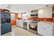 The kitchen has stainless steel appliances, white cabinets, and a pop of color at 5353 Starwood Pl, Sarasota, FL 34232