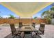 A brick patio with outdoor seating under a sunshade, perfect for entertaining or relaxing in the backyard at 5353 Starwood Pl, Sarasota, FL 34232