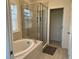 A luxurious bathroom with a soaking tub and a large glass enclosed shower with tiled walls and floors at 5521 Summit Gln, Bradenton, FL 34203