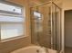 Bright bathroom featuring a soaking tub and glass shower enclosure with tiled walls and floors at 5521 Summit Gln, Bradenton, FL 34203