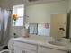 Bathroom featuring a single vanity with a white countertop, framed mirror, a window and tiled floors at 5521 Summit Gln, Bradenton, FL 34203