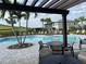 Outdoor community pool with palm trees and landscaping and seating under a wood pergola at 5521 Summit Gln, Bradenton, FL 34203