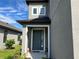 Inviting front entryway with a gray front door, white trim, and covered porch at 5521 Summit Gln, Bradenton, FL 34203