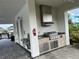 Close-up of the grill and sink area in the open-air poolside lounge, featuring stainless steel appliances and tile work at 5521 Summit Gln, Bradenton, FL 34203