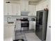 Bright kitchen featuring stainless steel appliances, white cabinets, and a view of the backyard at 5521 Summit Gln, Bradenton, FL 34203