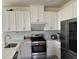 Modern kitchen with stainless steel appliances, white cabinetry, and a stylish backsplash at 5521 Summit Gln, Bradenton, FL 34203