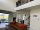 Open-concept living room with a view of the loft, lake, neutral tones, and a brown leather sofa at 5521 Summit Gln, Bradenton, FL 34203