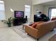 Comfortable living room featuring a large TV, leather sofa, neutral tile flooring, and stylish décor at 5521 Summit Gln, Bradenton, FL 34203